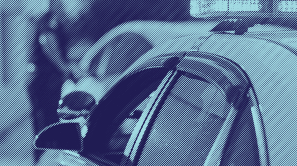 A stylized photograph of a police car in the foreground; the background is an out of focus police officer at the window of a stopped car