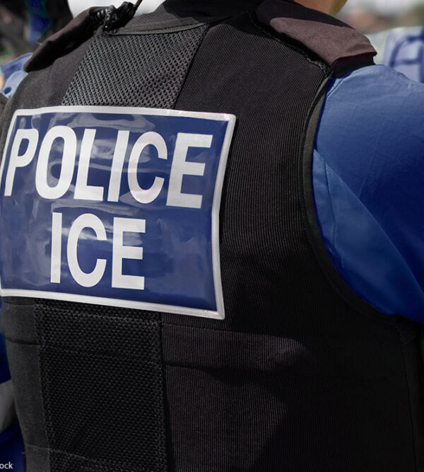 A photo of someone's back wearing a vest that says POLICE ICE