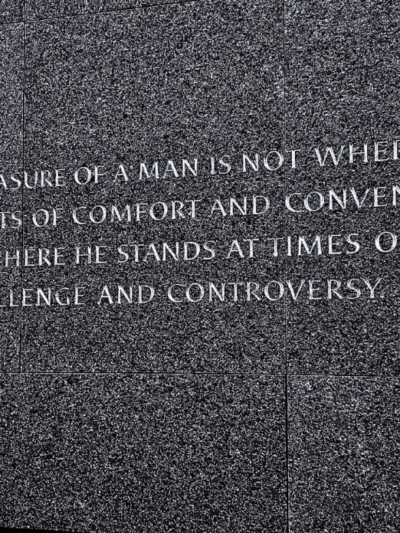 A photo of the text “The ultimate measure of a man is not where he stands in moments of comfort and convenience, but where he stands at times of challenge and controversy.” written on Dr King's monument in Washington DC