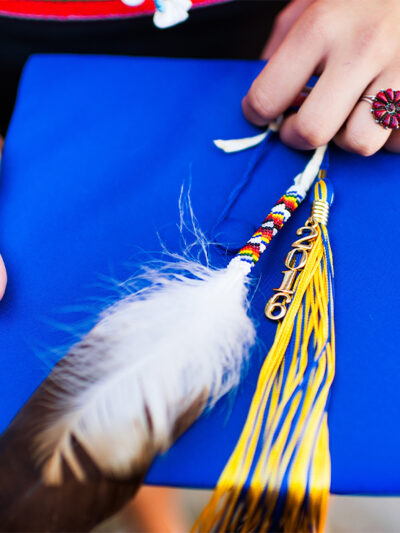 graduation cap with feather laid on top