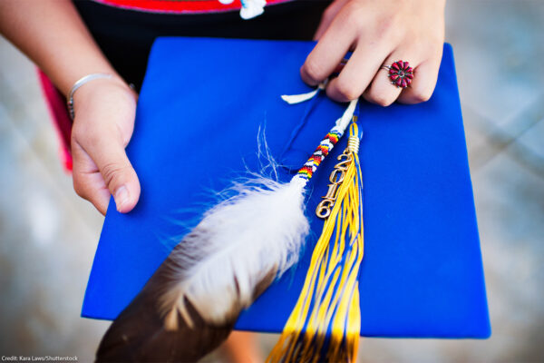 graduation cap with feather laid on top