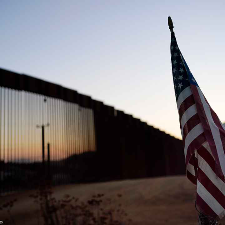 A flag sits just north of a new section of the US-Mexico border structure